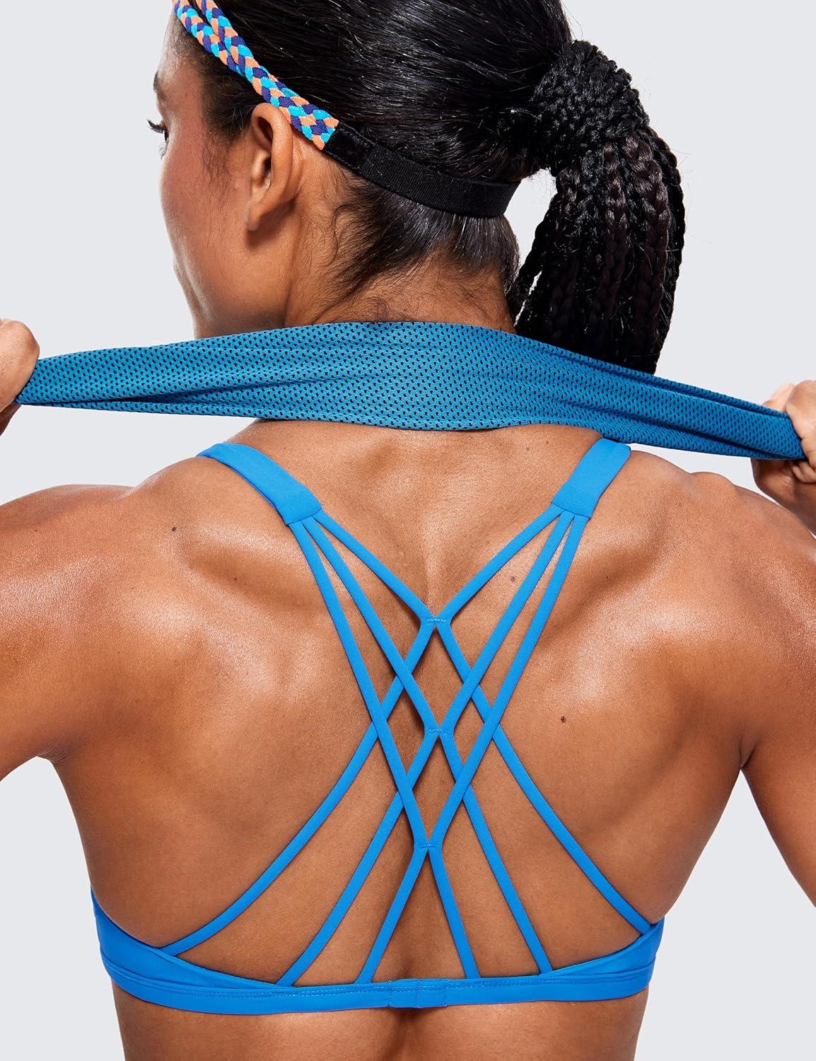 imageCRZ YOGA Womens Naked Feeling Criss Cross Sports Bra Strappy Back Padded Medium Support Wireless Gym Cami Workout YogaMadagascar Blue