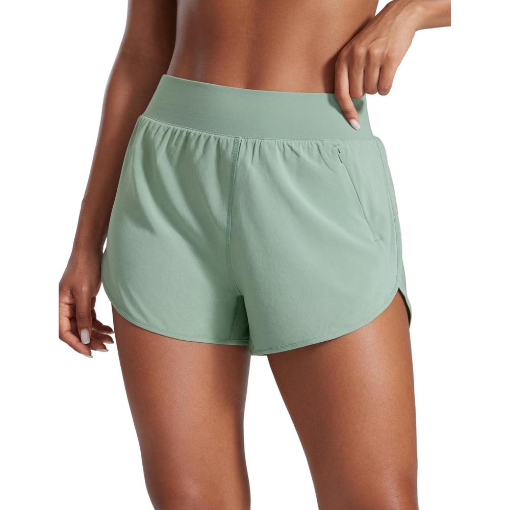 imageCRZ YOGA Dolphin Flat Waist Athletic Shorts for Women 3quot High Rise Quick Dry for Running Workout Gym Track with Zip PocketsGreen Palm Court