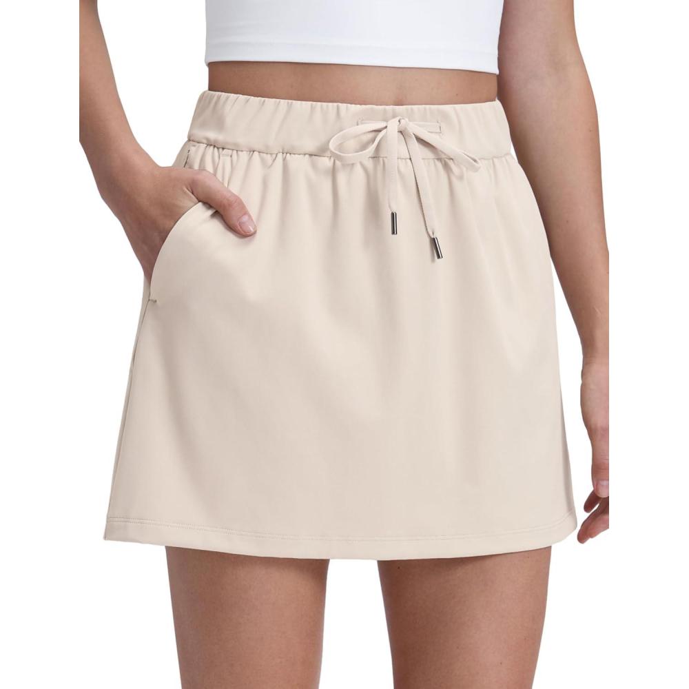 imageCRZ YOGA 4Way Stretch A Line Skirts for Women High Waitsted Mini Lined Tennis Work Drawstring Skort with PocketsMojave Tan